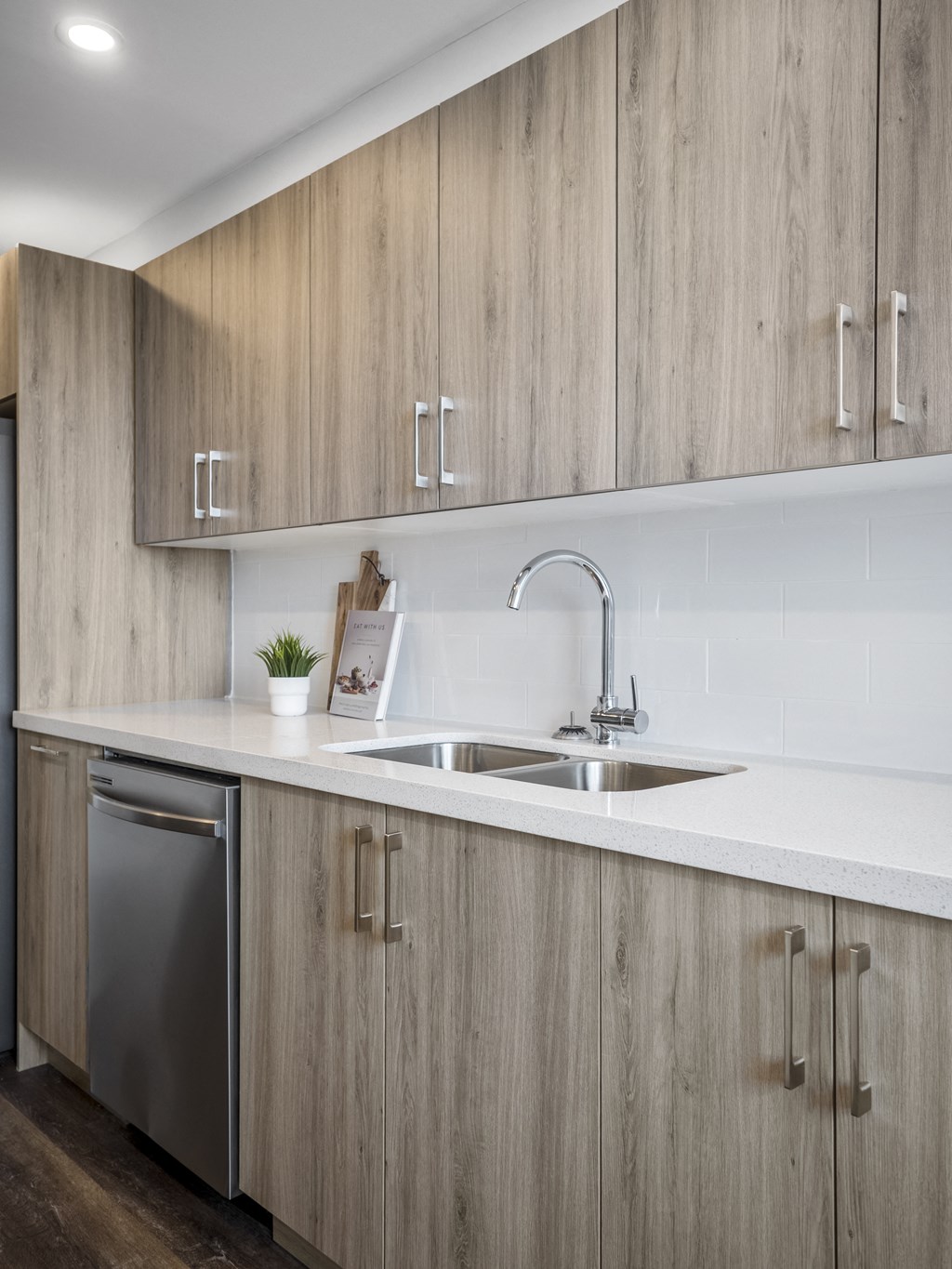 a kitchen with white countertops and wooden cabinets