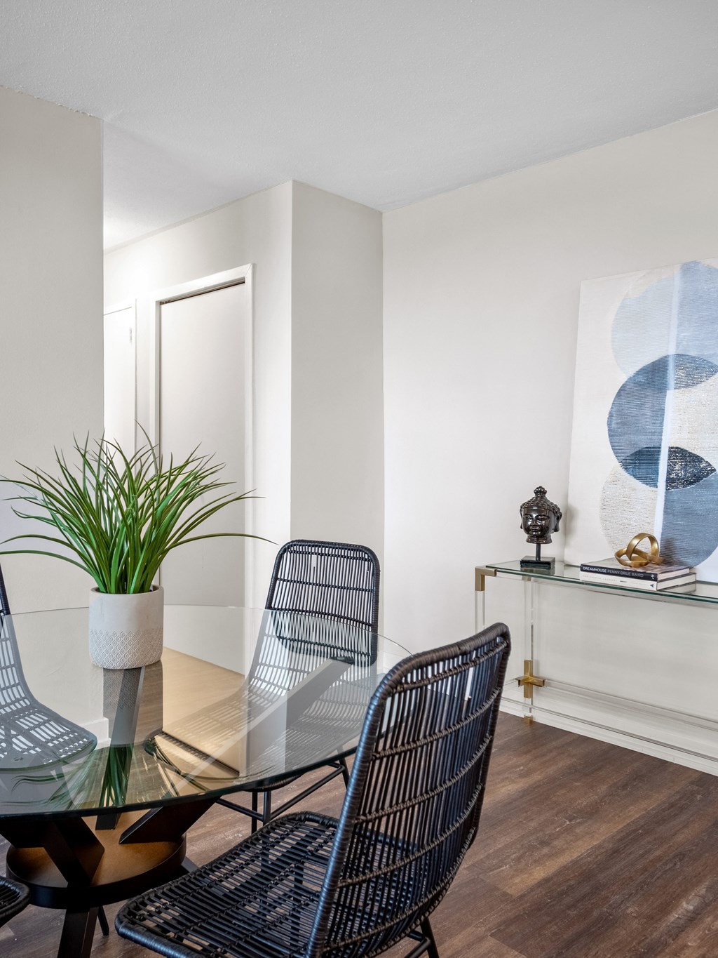 a dining room with a glass table and four chairs