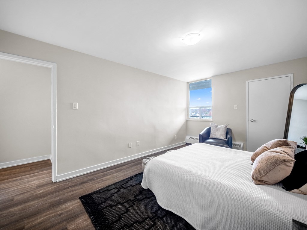 a bedroom with a large bed and a chair in a 555 waverly unit