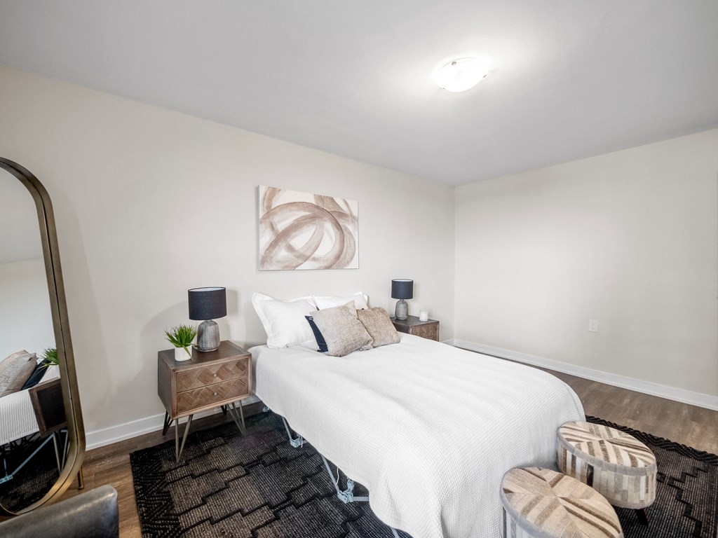 a bedroom with a white bed and a brown rug