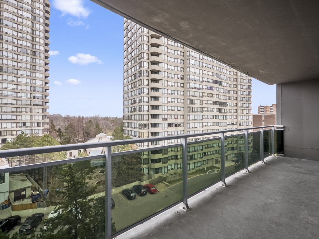 a balcony with a metal railing and a large apartment building in the background
