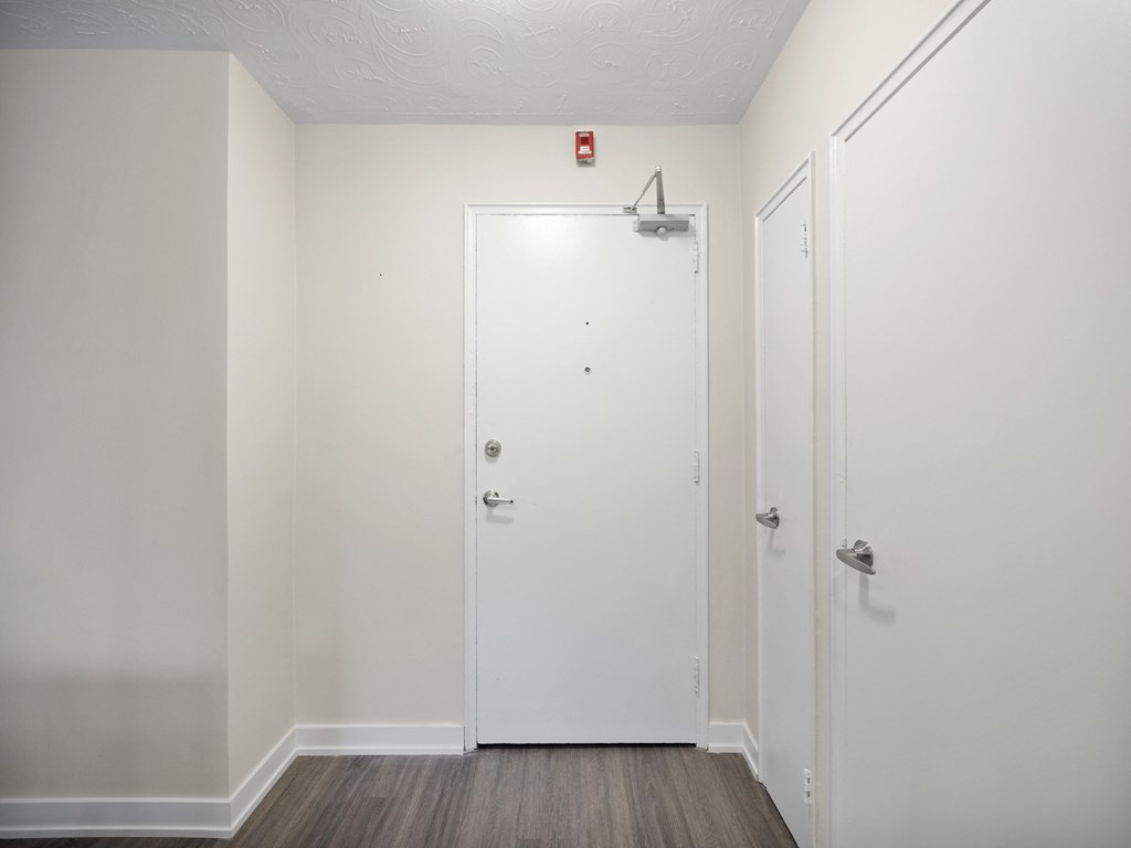 a bedroom with a white door and white walls