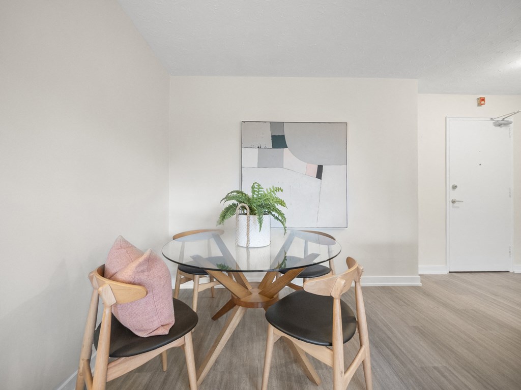 a small dining room with a glass table and three chairs