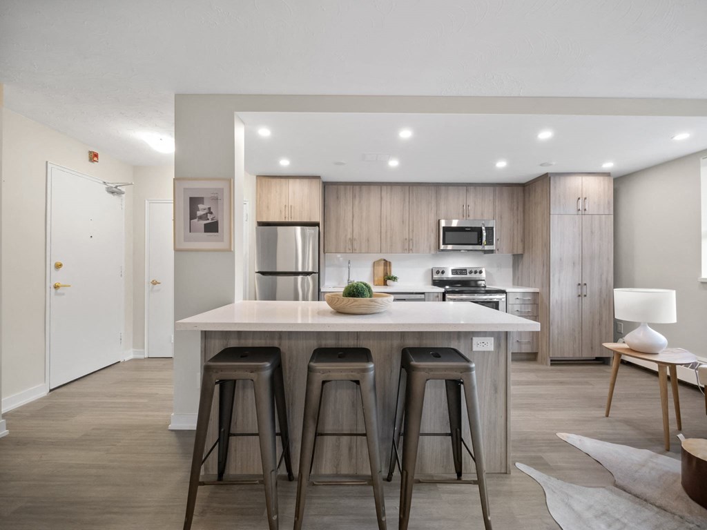 a kitchen with a large island with three stools in front of it