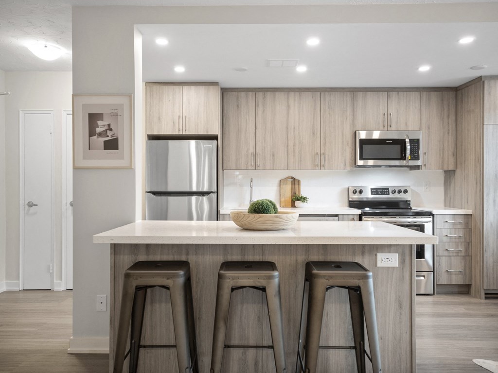 a kitchen with a large island with three stools in front of it