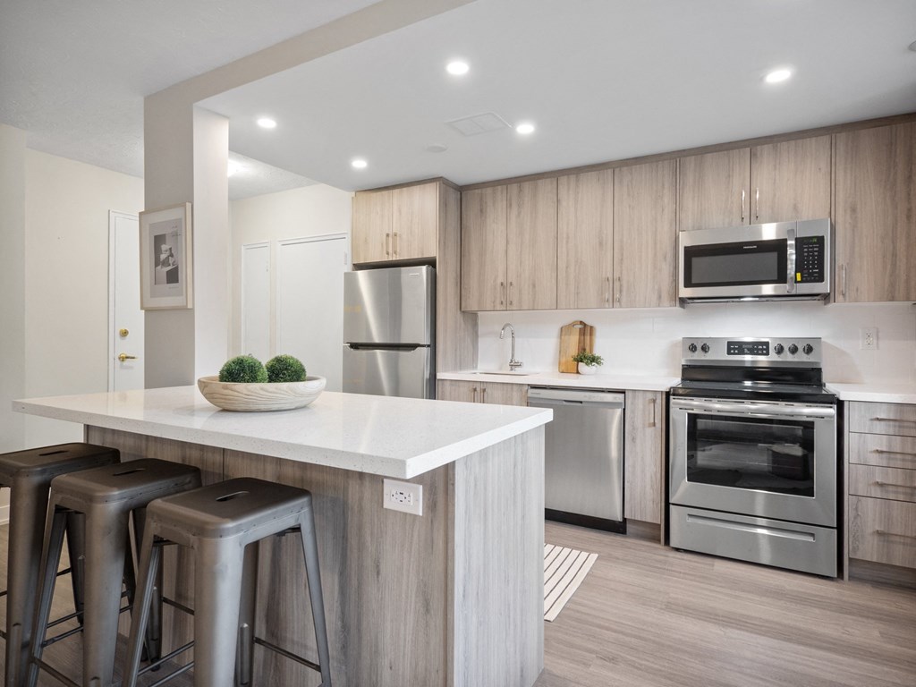 a kitchen with a large island with three stools in front of it