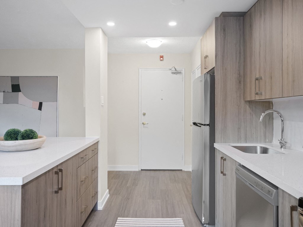 a kitchen with white countertops and wooden cabinets