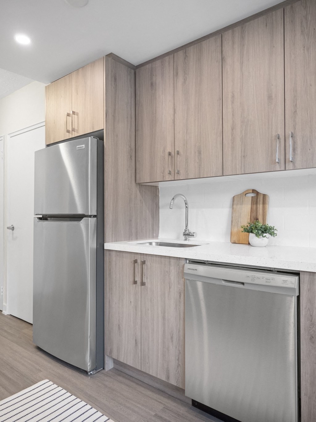 a kitchen with wooden cabinets and a stainless steel dishwasher