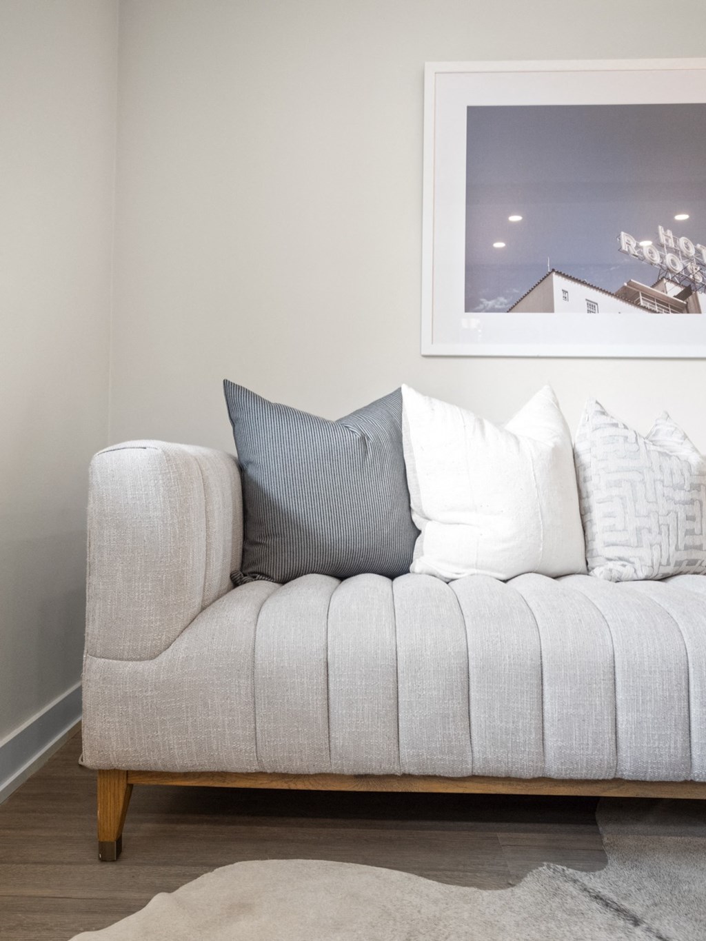 a sofa in a living room with a painting on the wall