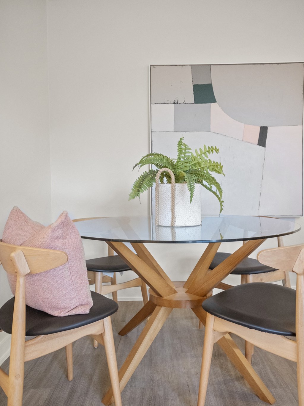 a dining room with a glass table and wooden chairs