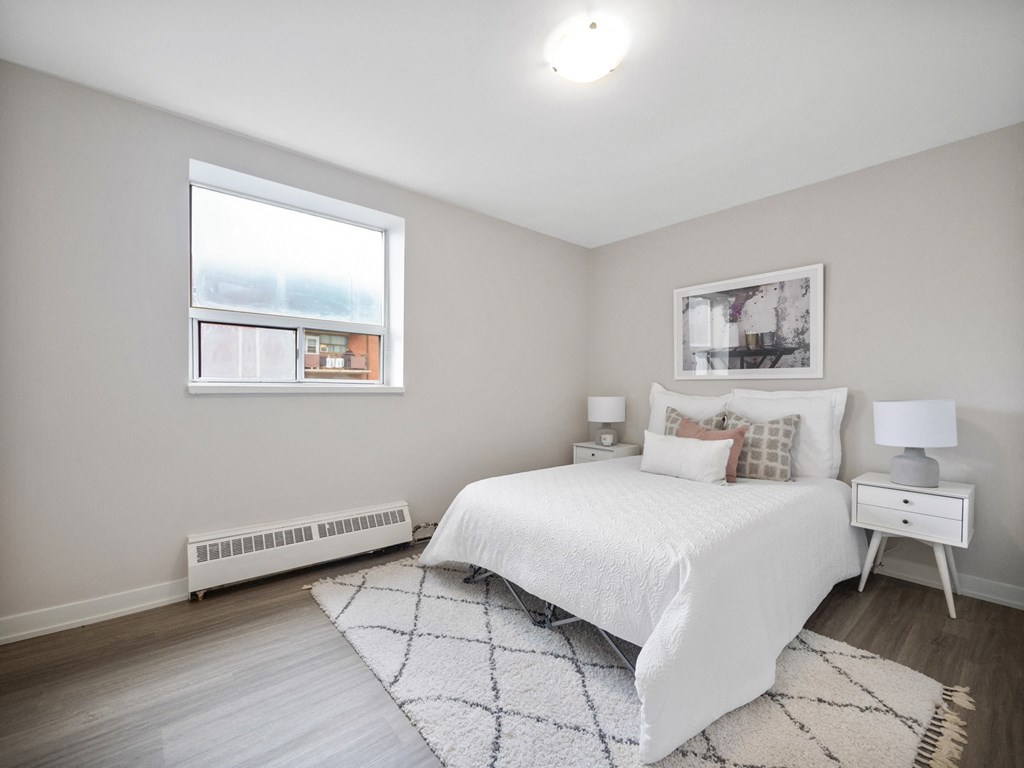 a bedroom with a bed and two windows