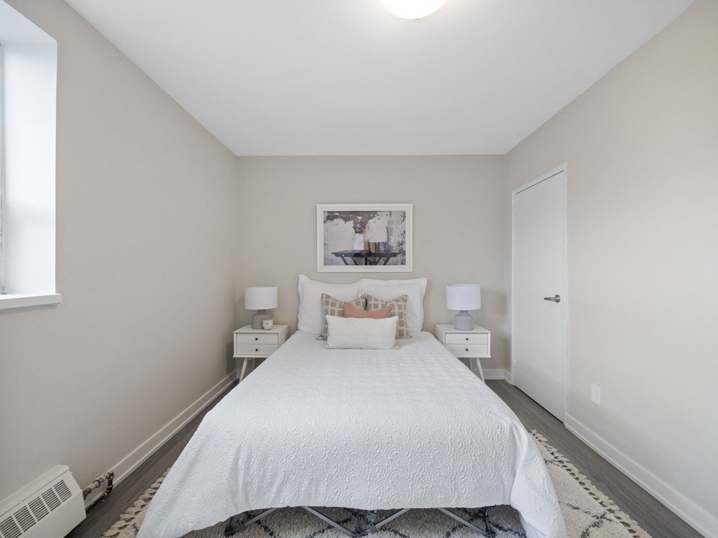 a bedroom with a large white bed and two white nightstands