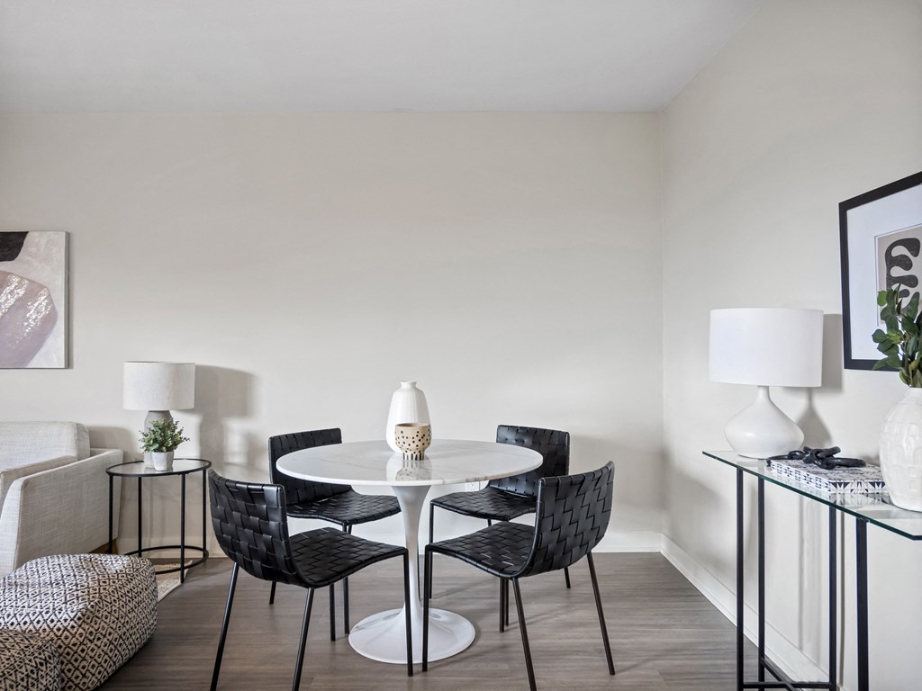 a dining area with a table and chairs and a couch in a 555 waverly unit