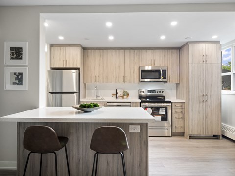 A modern kitchen with wooden cabinets and a white island.