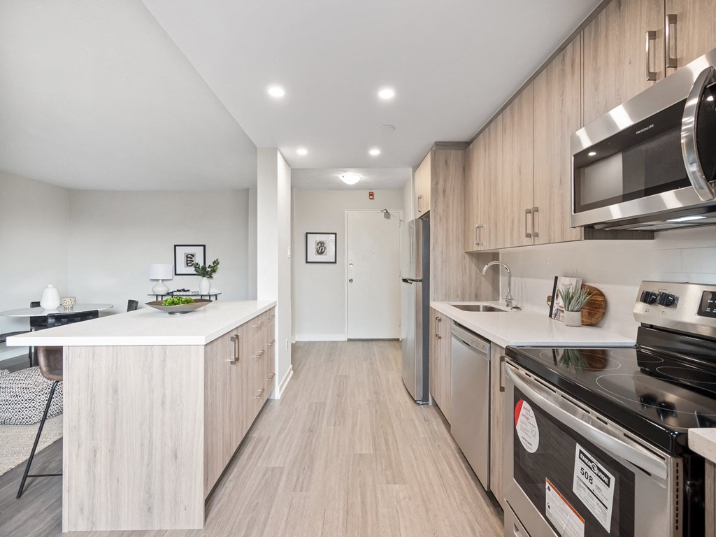 a kitchen with white countertops and wooden cabinets