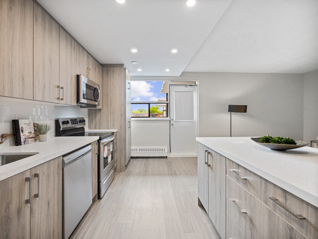 a kitchen with white countertops and wooden cabinets