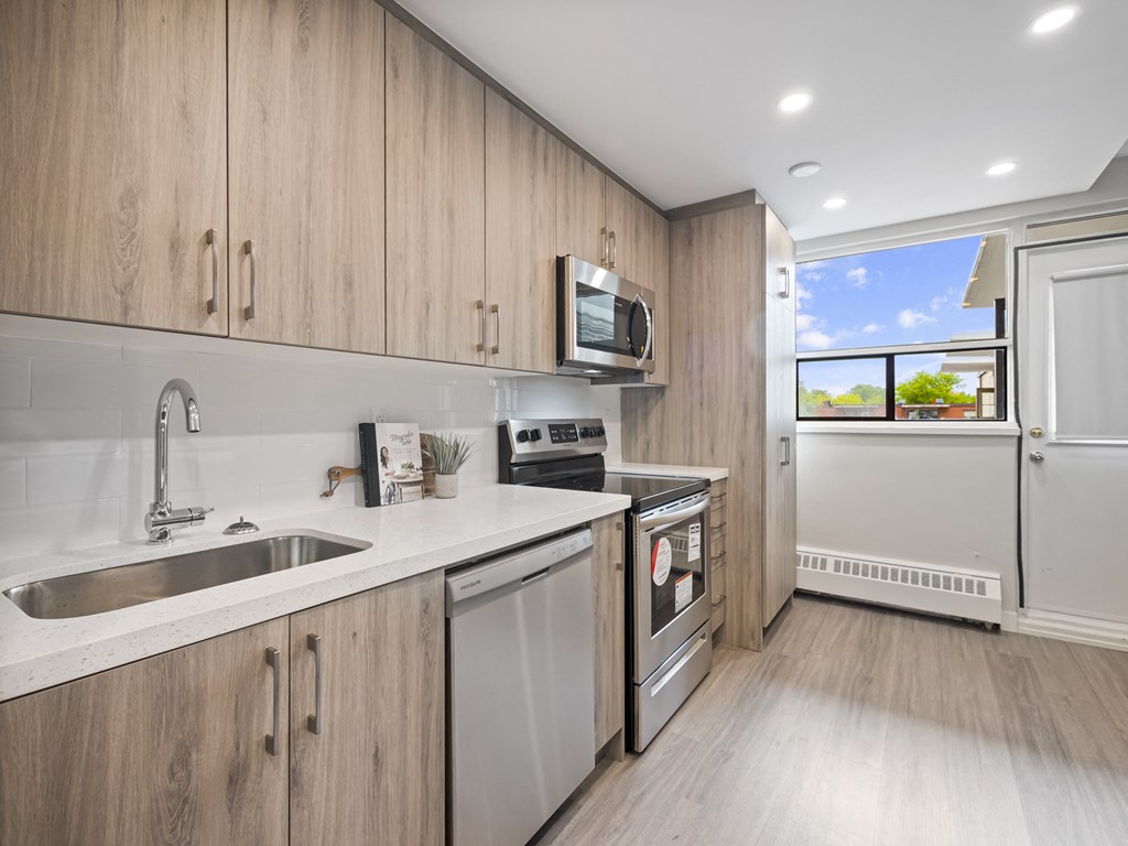 a kitchen with white countertops and wooden cabinets
