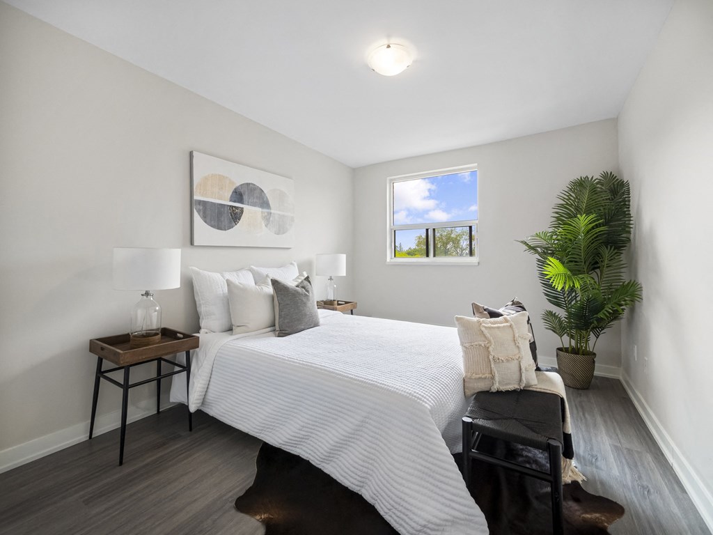 a bedroom with a large bed and a potted plant