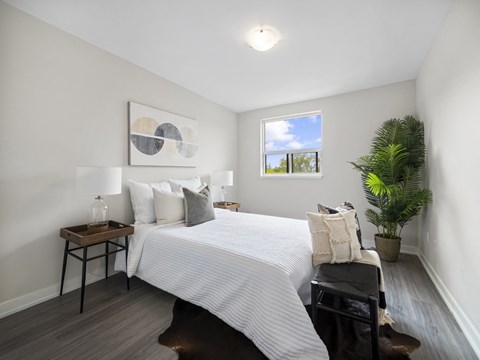 a bedroom with a large bed and a potted plant