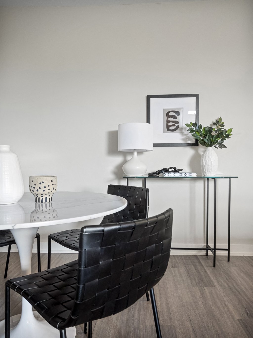 a dining room with a white table and black chairs
