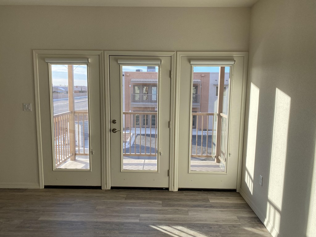 an empty living room doors and a balcony
