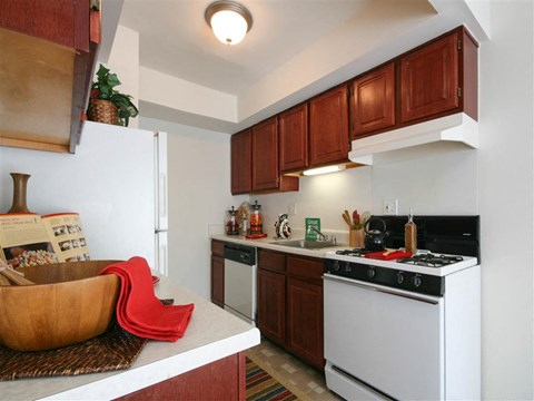 A kitchen with a white stove and wooden cabinets.