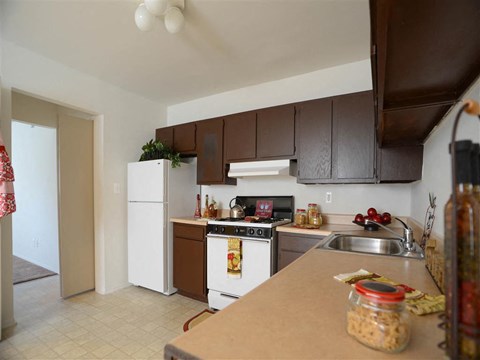 A kitchen with brown cabinets and a white fridge.