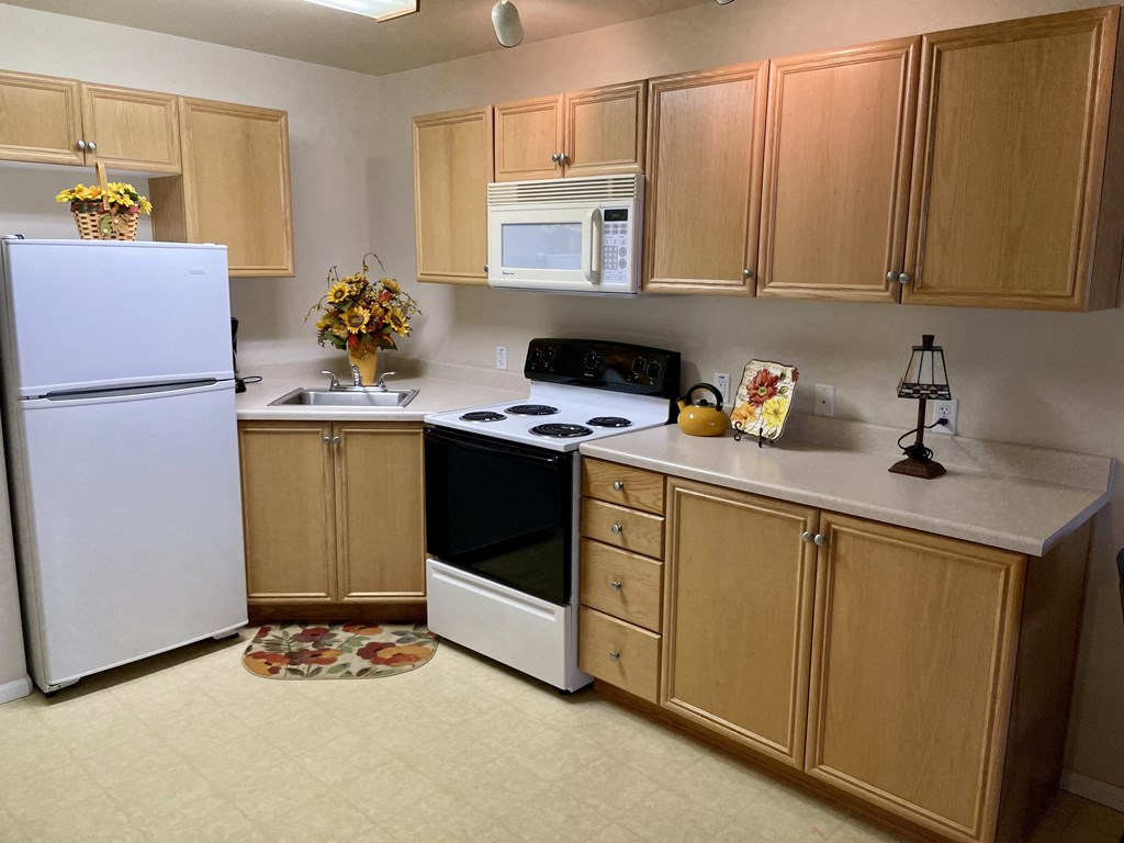 a kitchen with white appliances and wooden cabinets