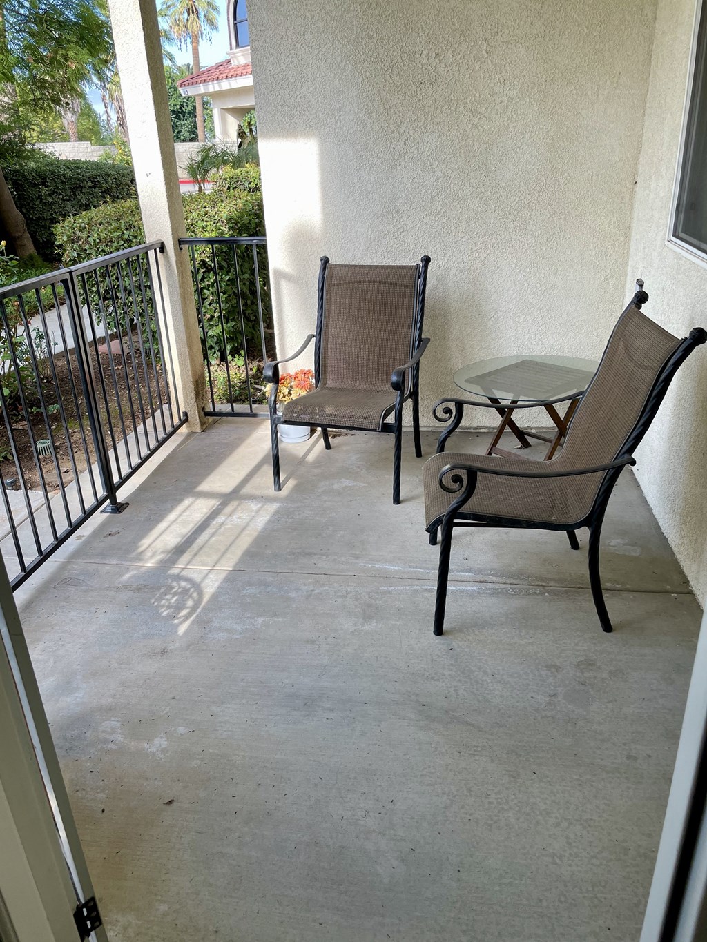 a patio with two chairs and a table on a balcony
