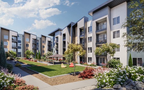 A row of modern apartment buildings with a landscaped garden in the foreground at The Village at Hawk View, Reno.