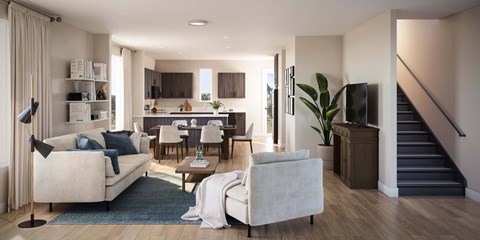 A modern living room with a staircase leading to the upper floor at The Village at Hawk View, Reno, Nevada.