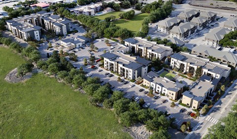 A bird's eye view of a residential area with multiple houses and green lawns at The Village at Hawk View, Reno, NV .