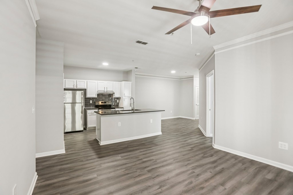 A spacious kitchen with a fan on the ceiling.