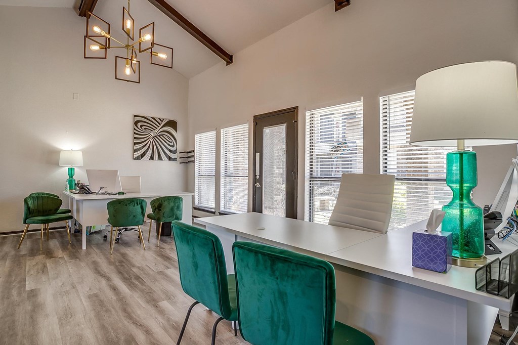 a dining room with green chairs and a white table and a desk with a lamp