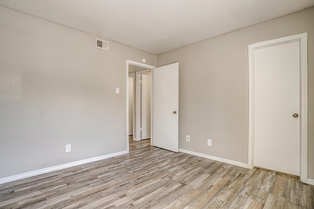an empty living room with wood flooring and white walls