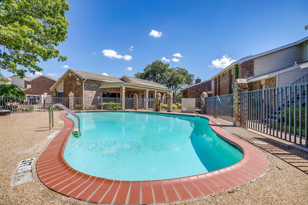 a swimming pool with a fence and a house with a pool