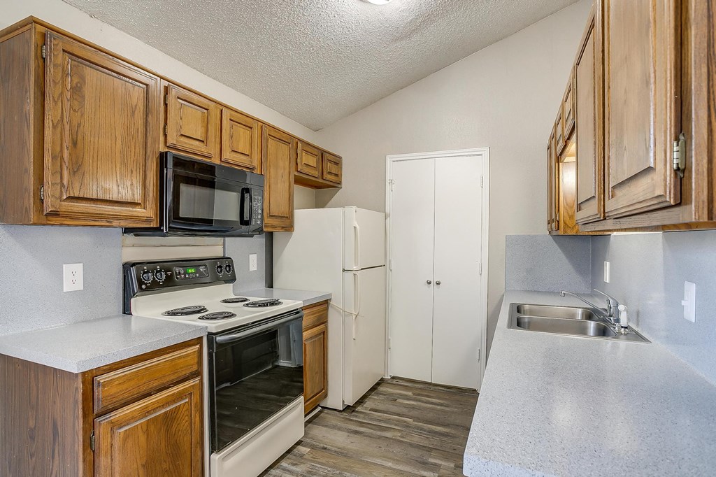 a kitchen with wooden cabinets and white appliances