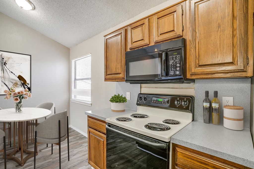 a kitchen with a stove and microwave and a dining table