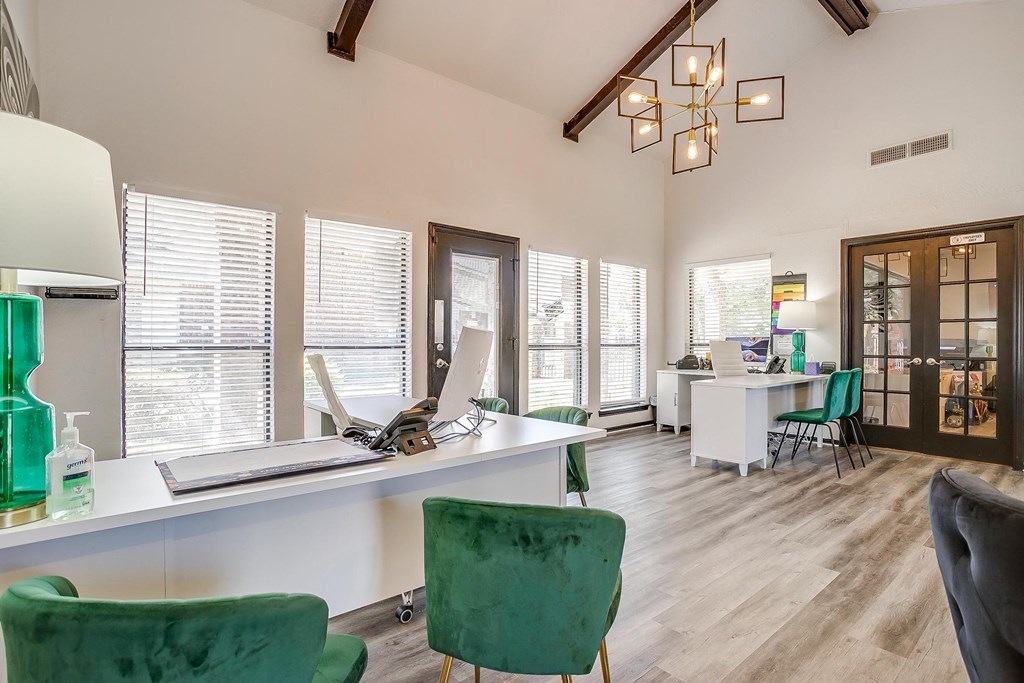 a home office with green chairs and a desk with a laptop