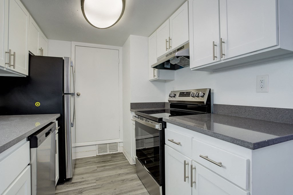a kitchen with white cabinets and black appliances and a refrigerator