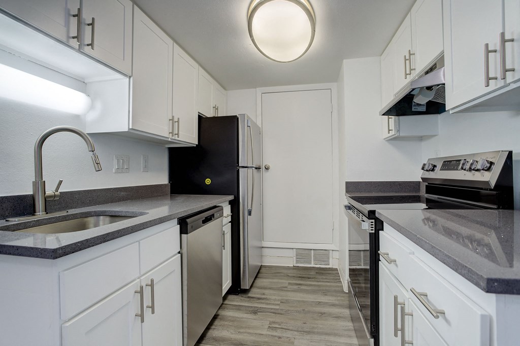 a kitchen with white cabinets and a sink and a refrigerator