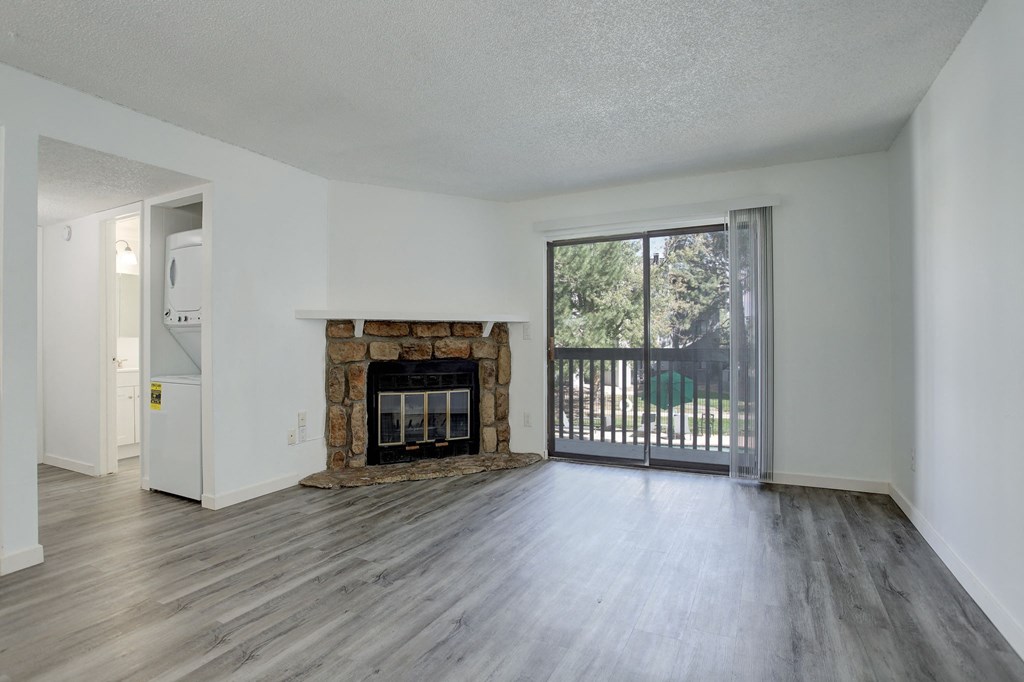 an empty living room with a fireplace and a sliding glass door
