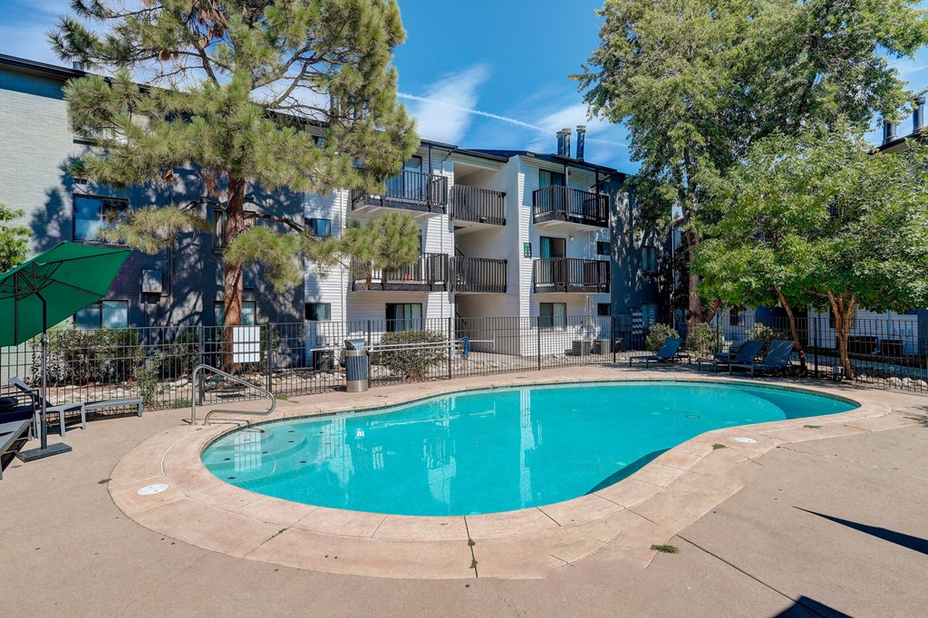 a swimming pool with an apartment building in the background