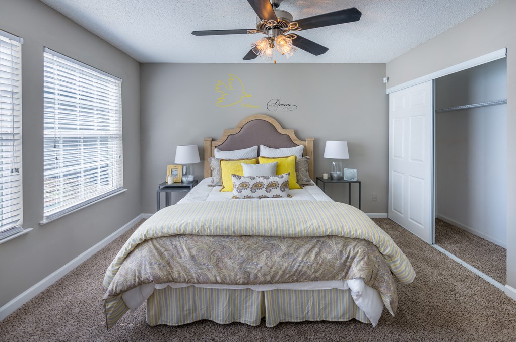 a bedroom with a large bed and a ceiling fan
