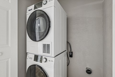 Two white washing machines stacked on top of each other.