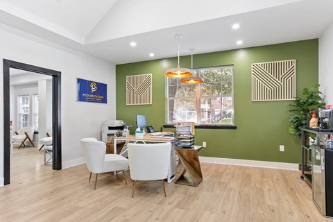 a dining room with green walls and a table with white chairs
