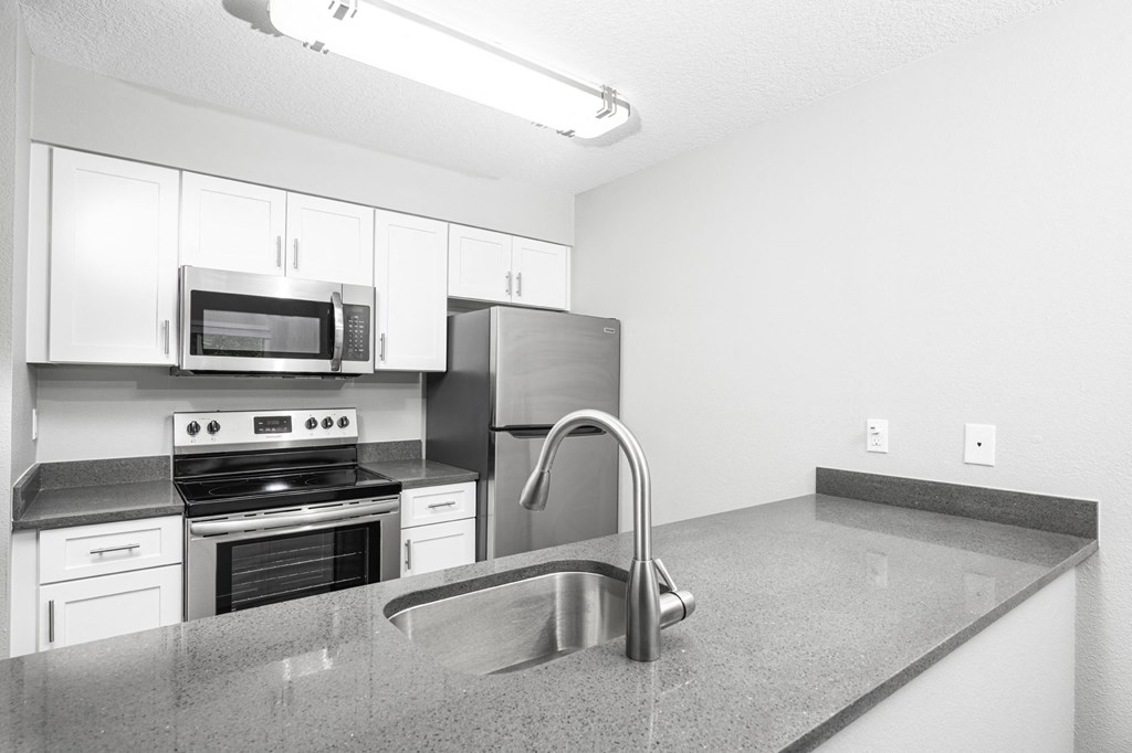 a kitchen with a sink stove and microwave