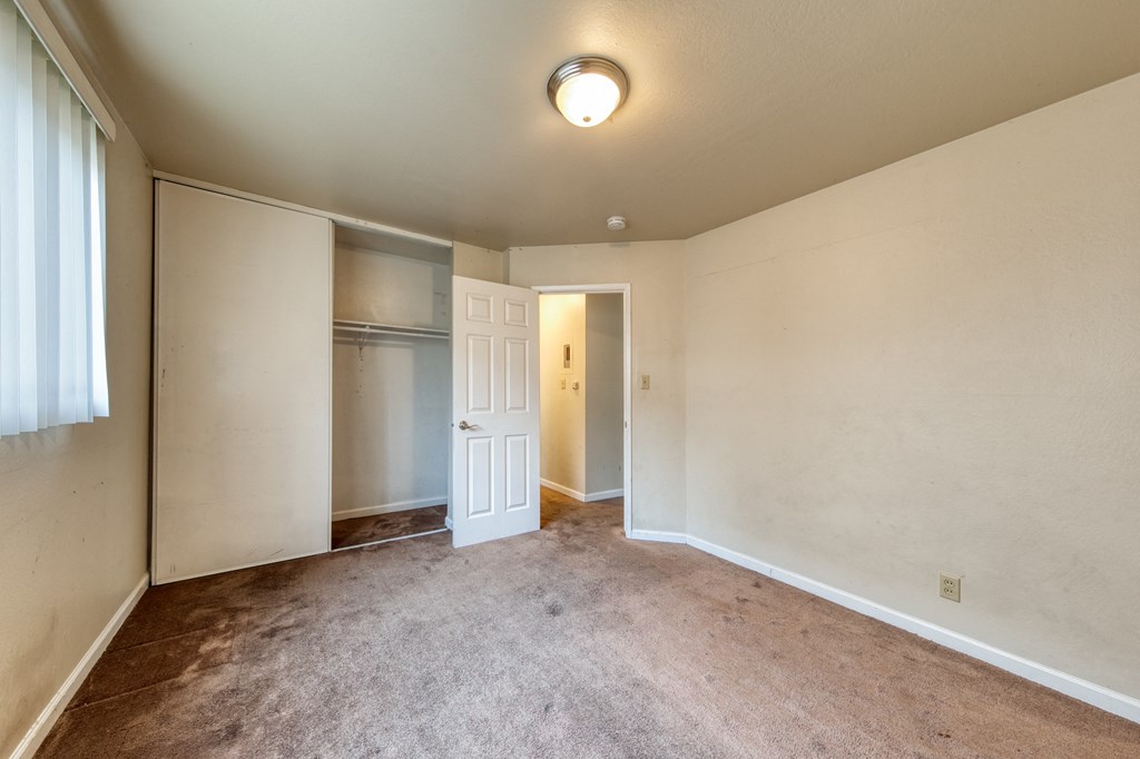 a bedroom with a closet and a window