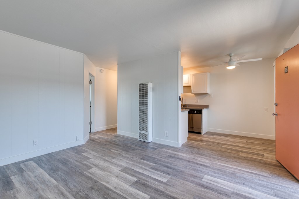 a bedroom with hardwood flooring and white walls