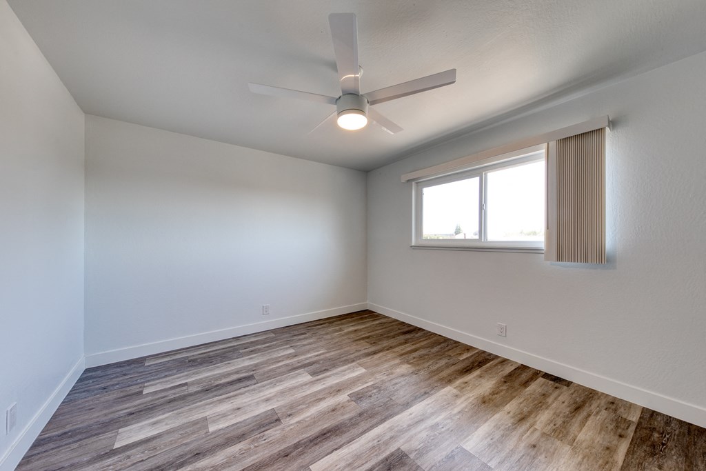 a bedroom with hardwood floors and a ceiling fan